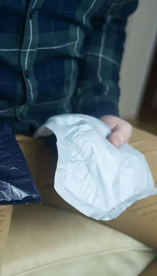 Image of man holding incontinence pads as part of overactive bladder treatment Newcastle-under-Lyme